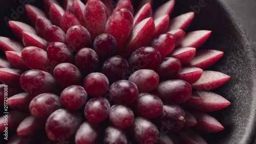 Grey matte panel and grape halves arranged in tight radial grid on bowl, airy neutral tone and micro-focus clarity