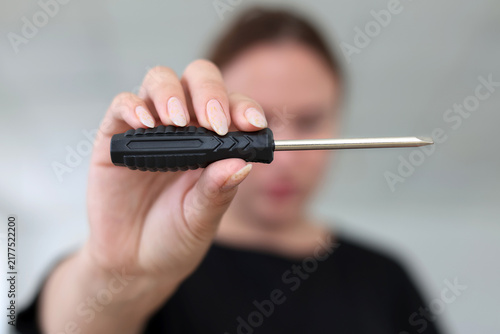 Fotografie Woman holding flathead screwdriver tool repair and DIY concept