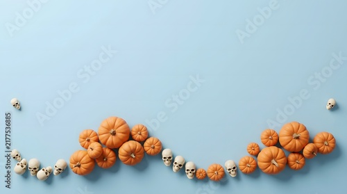 Small decorative pumpkins and white beads arranged in a wave pattern on blue background