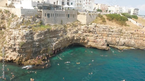 People Cliff Diving and Swimming in Turquoise Water at Polignano a Mare Puglia Italy