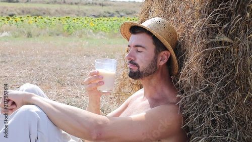 Attractive Shirtless Farmer Drinking Fresh Milk in Sunflower Field