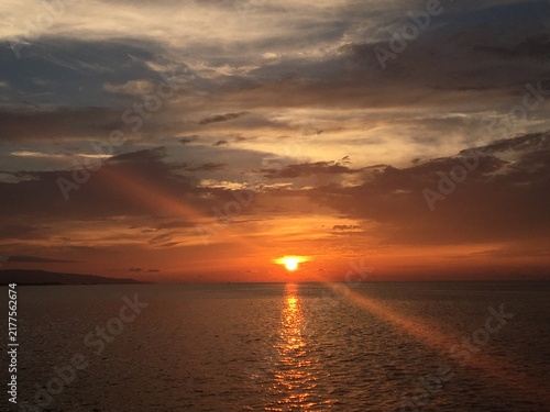 Obraz na płótnie 海に沈む美しい夕日と橙色の空