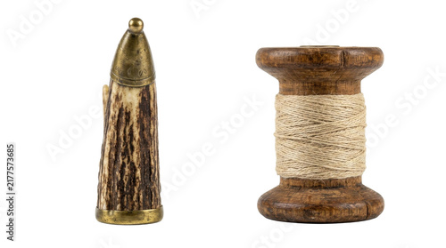 Fotografía Antique antler handle tool and wooden spool of twine on a white background
