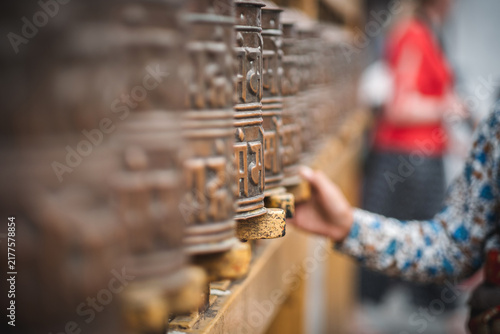 Foto Female hand spins numerous Buddhist prayer wheels in Kathmandu Nepal