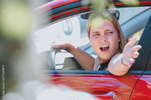 woman driving aggressively, protesting furiously out the window