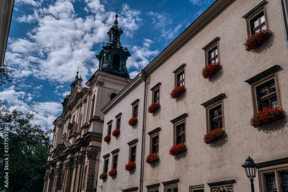 Fototapeta premium Historic building facade with red flowers in Krakow, Poland