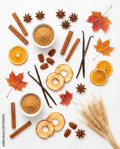 Autumn baking ingredients collection with cinnamon sticks, dried oranges, spices and maple leaves isolated on white background