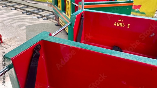 Фотография Colorful red and green passenger cars of a miniature train attraction at an amus