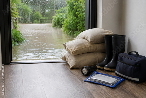Home Flood Readiness Kit Beside a Rain-Swept Doorway
