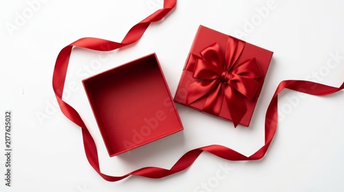 Open red gift box with satin ribbon bow on white background in top view flat lay.