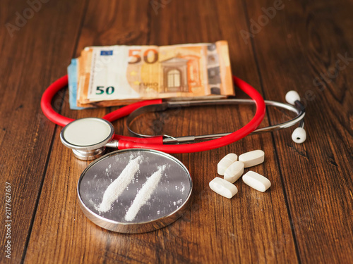 Картината върху платно Stethoscope rests beside brain model and tow line of drugs on small mirror on wooden surface