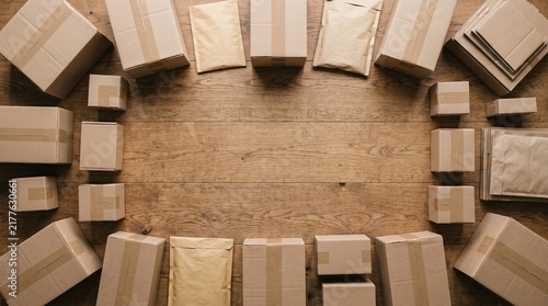 Collection of cardboard boxes and envelopes arranged on a wooden surface for shipping and delivery