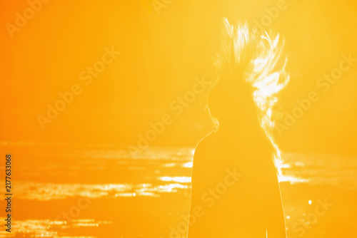 Obraz na plátne Energetic teenage girl with flying hair in golden sunrise light, concept of youth, freedom and joy of life