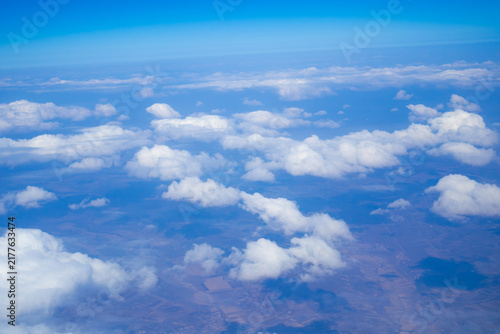 Beautiful aerial view of white clouds over the landscape seen from an airplane