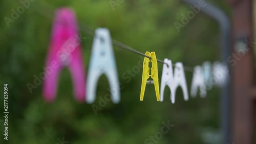 Focus Pull Shot of Plastic Pegs on Clothesline Outdoors