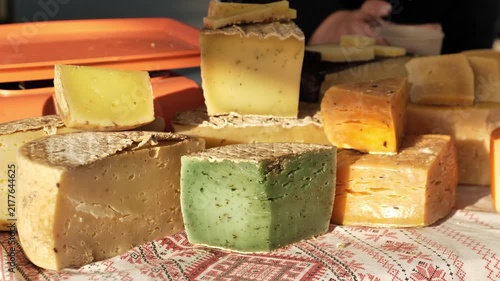 Artisan cheese assortment on a market stall, offering organic rustic dairy products