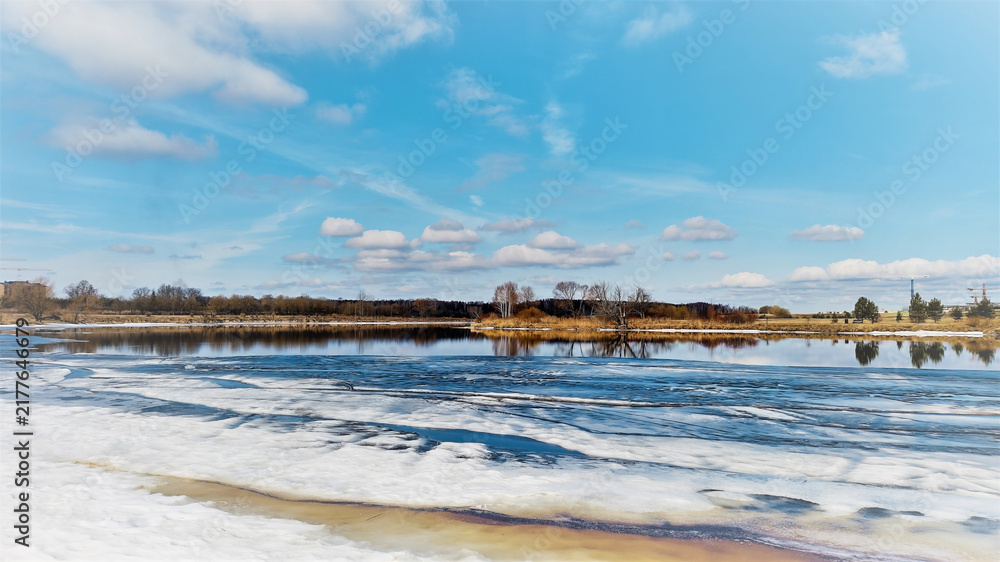 Obraz premium A stunning springtime landscape featuring a wide river with melting ice floes.