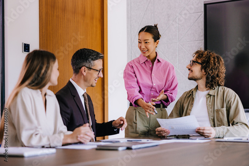 Smiling Team Discussing Reports in Office Meeting — Collaborative Business Presentation and Strategy Session