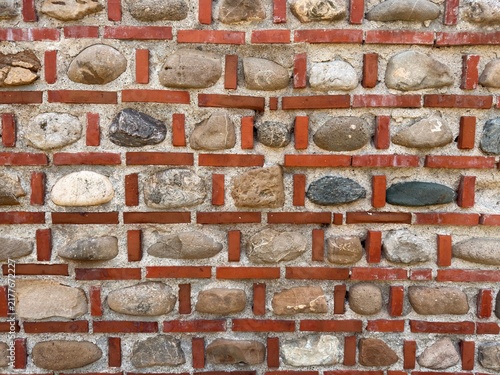 Antique brick and stone wall background, medieval masonry pattern texture.