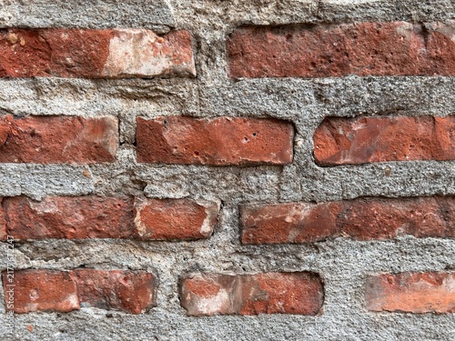 Old red brick wall texture, weathered vintage brickwork background close up.