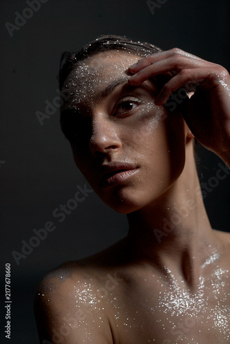 Foto A portrait of a nude young woman with white artistic makeup on her face and neck