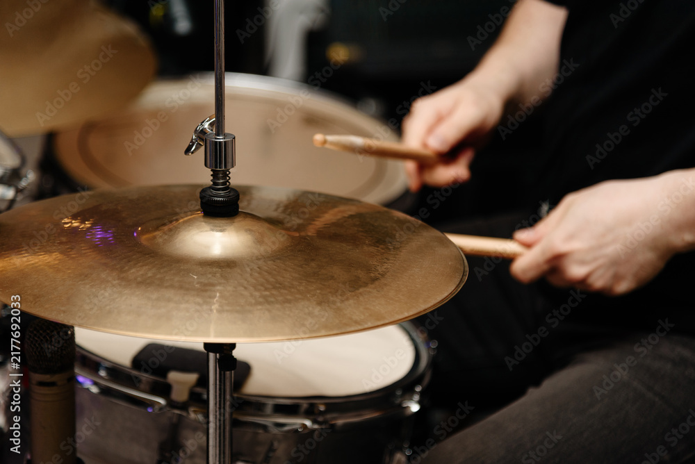 Obraz premium drummer plays drumset at rock concert with wooden drum sticks, close-up view of hands