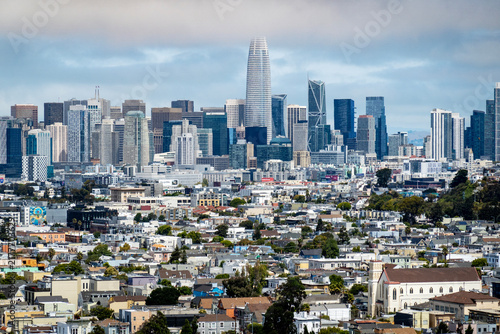 Foto sf skyline-The prominent San Francisco skyline rises dramatically behind a sprawling expanse of densely packed urban homes and neighborhoods