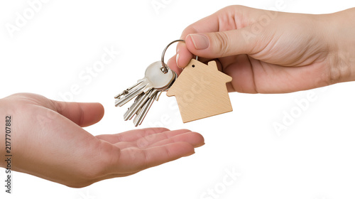 Isolated hands exchanging house keys with a wooden keychain, symbolizing real estate transaction.