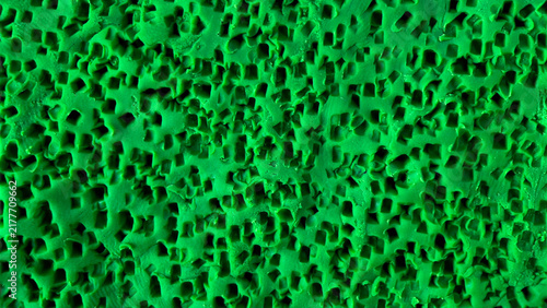 фотографія Macro close-up of vibrant green plasticine texture featuring perforated square p