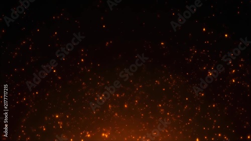 Glowing orange sparks and embers floating on a dark background for design and texture