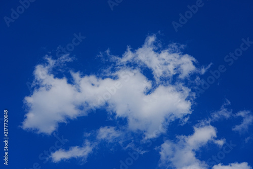 Bright blue sky with large fluffy white cumulus cloud