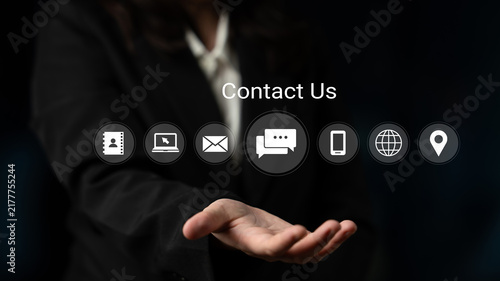 Fotografía A professional businesswoman extends her hand, featuring various communication icons on a dark background