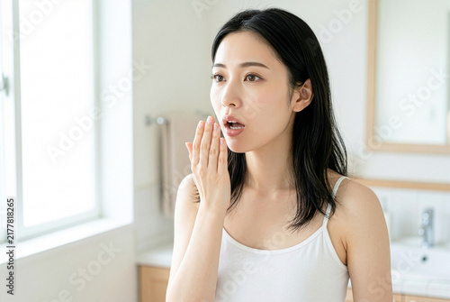 Obraz na płótnie 口元に手を当てて口臭をチェックする日本人女性｜口臭ケア・オーラルケアのイメージ