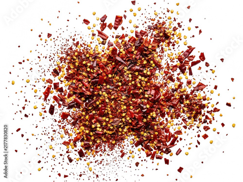 Dried red chili pepper flakes and seeds scattered isolated on transparent background for culinary food photography