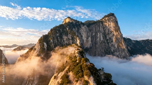 Majestic mountain peaks rising above a sea of clouds under a clear blue sky