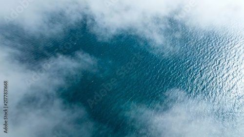 Aerial view of ocean surface partially covered by clouds