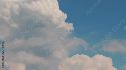 White puffy clouds drifting across a bright blue sky during a sunny afternoon capturing nature in motion