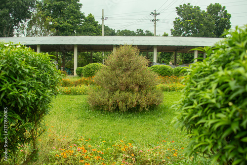 Tiered potted plant tower standing on lush grass in summer garden.