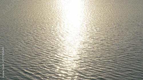 Sunlight sparkling reflection on rippling water surface