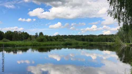 Beautiful river reflection with moving clouds in blue sky summer nature timelapse