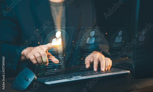 Businessman touching candidate profile hologram on screen, recruitment process, human resources management and candidate selection concept.