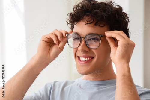 Vision correction and eye health, young man adjusting glasses for clear sight...