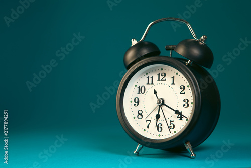 Fotografie Retro alarm clock on a blue background with copy space
