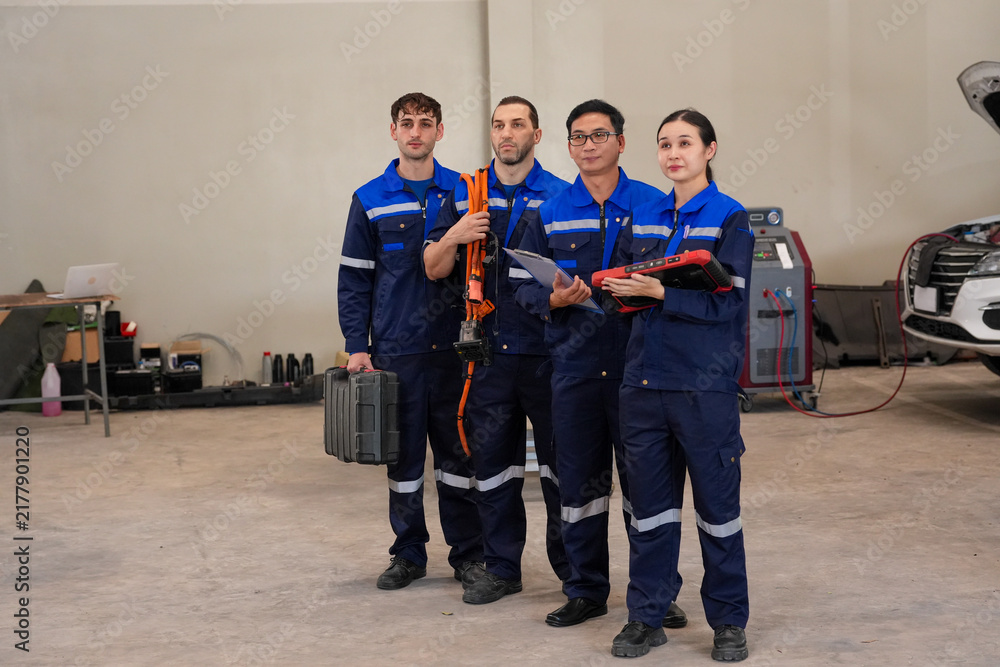 Fototapeta premium Technician team mechanic workshop uniform tool vehicle repair garage diagnostic, diverse auto service crew standing in repair bay with equipment and car