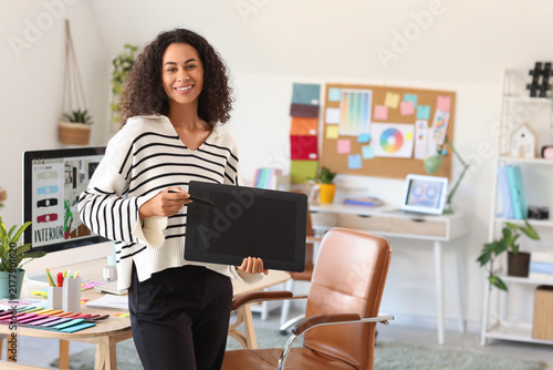 Female African-American interior designer with graphic tablet in office