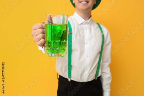 Man with mug of beer on yellow background. St. Patricks Day celebration