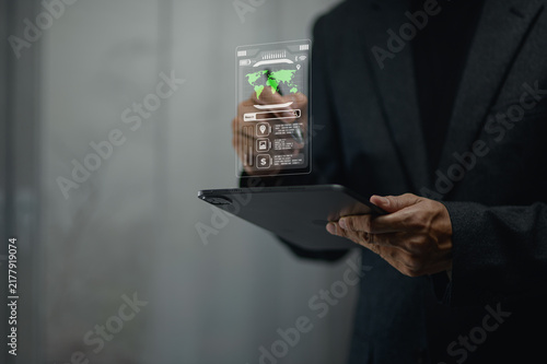 Businessman in dark suit holding tablet with transparent holographic digital interface