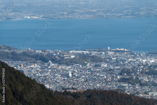 Telephoto aerial view of Beppu city dense urban buildings, residential areas, and Beppu Bay from Mt. Tsurumi.
