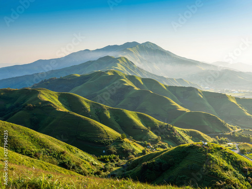 Sunlit rolling green mountains in the morning light