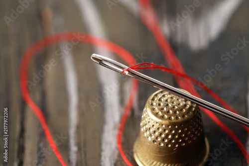 A Needle With Thread And A Thimble